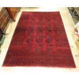 A hand woven Afghan rug the multi lined border enclosing red ground field with three rows of