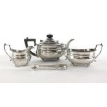 A three piece silver tea set together with a pair of silver hallmarked sugar tongs comprising of a