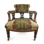 An Edwardian walnut open sided tub chair with cream and green upholstery on turned legs. h.