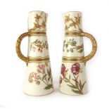 A pair of Royal Worcester ewers, the blush ivory ground decorated with gilding and floral sprays,