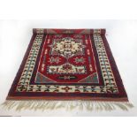 A hand made Turkish rug the triple lined border enclosing a red ground field with central medallion,