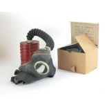 A WWII gas mask in original cardboard box with instructions printed to lid,