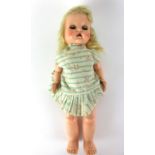 A 1950/60's plastic walking doll, with rocker blue eyes, open mouth showing one tooth,