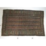 A hand woven Persian rug the multi line border with spider motifs enclosing a lined field, l.