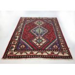 A hand woven Turkish rug the triple lined border surrounding a red ground field, l. 190 cm, w.