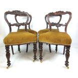 A set of four early 19th century mahogany dining chairs with carved top and back rails over
