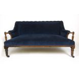 An early 19th century rosewood framed two seat settee with out-swept arms on turned supports and