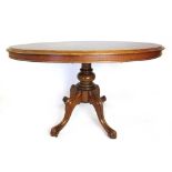A Victorian mahogany tilt top breakfast table, the oval top over turned column and four swept legs,