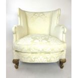 A Victorian arm chair upholstered in a white gold floral fabric with later gilded mahogany legs, h.