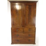 An early 19th century mahogany linen press with two cupboard doors enclosing four sliding trays