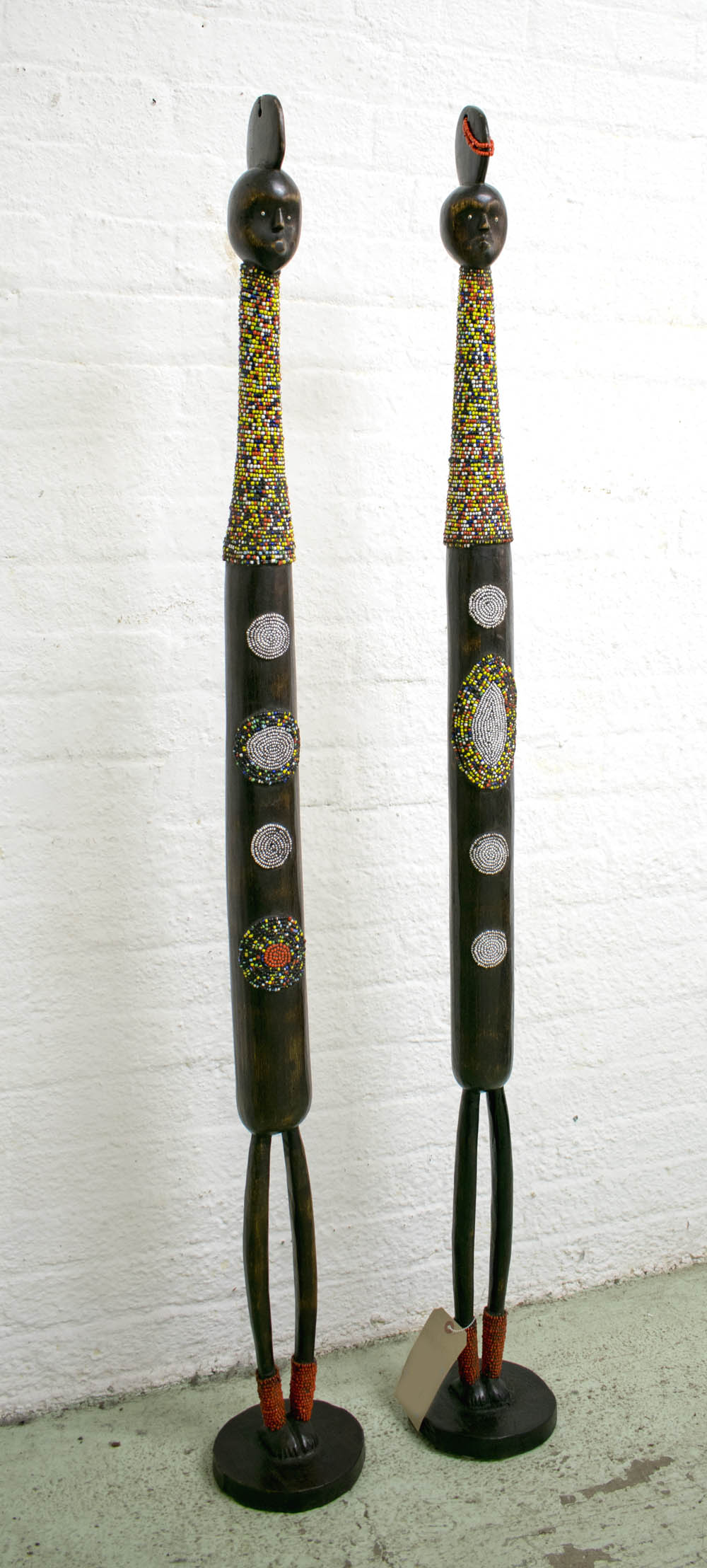 LARGE TIKAR DOLLS, a pair, carved wood with colourful beaded decortaion, each 153cm H.