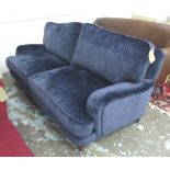 SOFA, two seater, in the Howard style in a Prussian blue velvet on turned feet with castors,