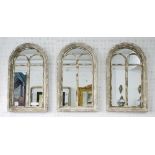 MIRRORS, a set of three, arched top in distressed effect metal and wooden frames, 95cm, x 55cm.