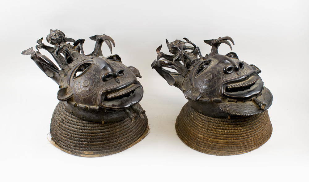 TRIBAL MASKS, an imposing companion pair, West African bronze with coiled Rafia head rests,