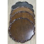 TRAYS, three similar, George III mahogany circular with pie crust edges and a lobed table top,