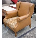 ARMCHAIR, with small wings, in tanned leather with cheetah patterned seat, on turned legs,