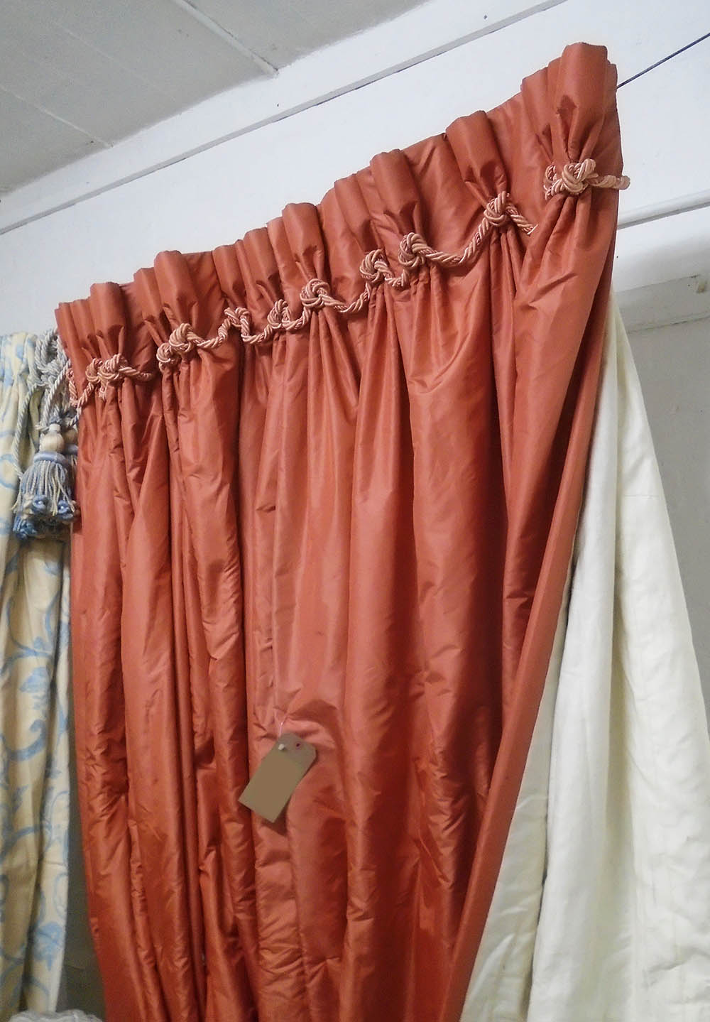 CURTAINS, a pair, in salmon coloured fabric, lined and interlined, 84cm W gathered x 255cm drop,