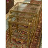 NEST OF THREE TABLES, 1970s French gilt brass with glass tops over stretchered square supports,