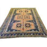 ANTIQUE KAZAK CARPET, 297cm x 225cm, rows of geometric medallions on a terracotta field,