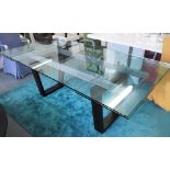 DINING TABLE, with glass top and pull out leaves to end on a metal and ebonised base,