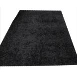 RUG, in black synthetic fibre by rug mark, 231cm x 163cm.