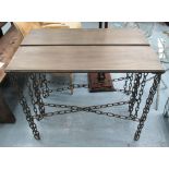 CONSOLE TABLES, a pair, with bronzed top on chain link base, 101cm x 31cm x 83cm H.