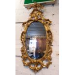 WALL MIRROR, George III giltwood with later oval plate in a foliate scroll surround,