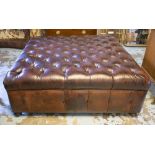 HEARTH STOOL, buttoned brown leather of large square proportions on bun feet and castors,