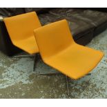 EASY CHAIRS, a pair, Italian designer style in orange leather finish on metal swivel bases,