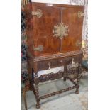 CABINET ON STAND, early 20th century amboyna with two doors enclosing a cellarette, tray and shelf,