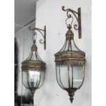 WALL HANGING LANTERNS, a pair, in a bronzed filigree frame with brackets, 80cm H.