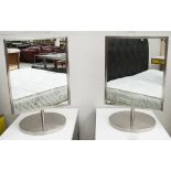 DRESSING MIRRORS, a pair, 1970's stainless steel rectangular and revolving on circular bases,