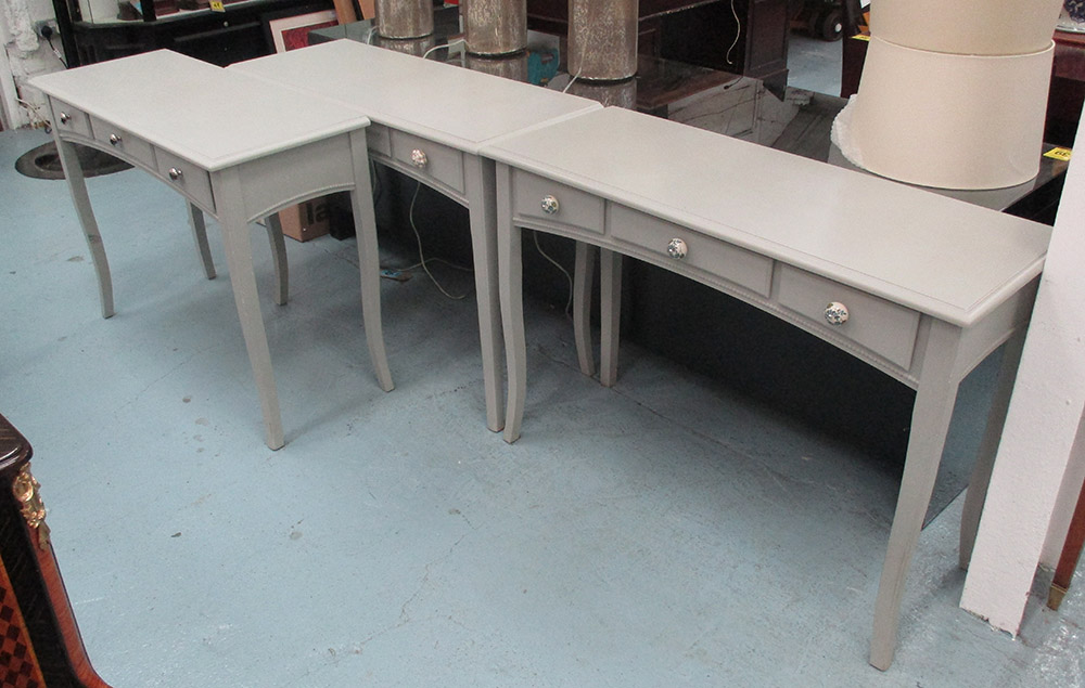 CONSOLE TABLES, three, each having three drawers with slender cabriole legs in a grey finish,