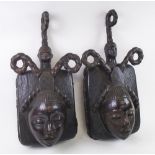 EKOI TRIBAL FACE MASKS, a pair, West African carved wood, each 66cm H x 32cm W max.