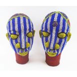 IFE BEADED HEADS, a companion pair, of colourful design, each 36cm H.