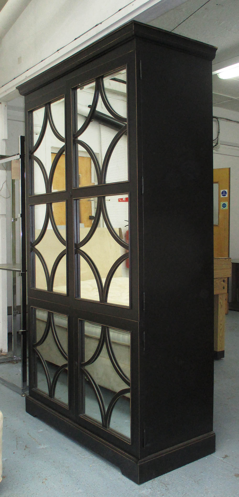TALL CABINET, black with a pair of mirrored doors with decorative astragal design,