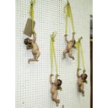 SWINGING CHERUBS, a set of four attached to ribbons, in resin, 56cm overall.
