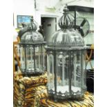 CROWN TOP STORM CANDLE LANTERNS, a pair, glass lined metal frames with hooks, 65cm H x 32cm diam.