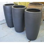 PLANTERS, a set of three, in black painted ceramic, 47cm diam x 90cm H.