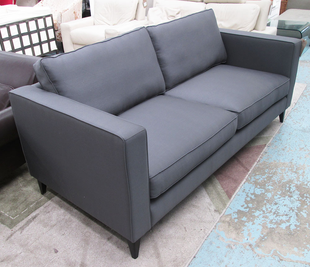 SOFA, two seater in charcoal fabric on square ebonised supports, 196cm L.