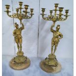 CANDELABRA, a pair, with gilt metal figures holding aloft five sconce torcheres, 62cm H x 23cm.