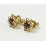 GOLD STUD EARRINGS, each set a garnet surrounded by eight diamonds.