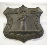 HERALDIC SHIELD, depicting a carved ebonised crest bearing motto 'Dean le Dochas', 83cm W x 77cm H.