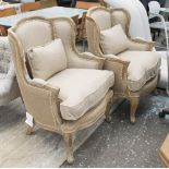 WINGBACK ARMCHAIRS, a pair, in beige fabric on ornate wooden frames, 75cm W.