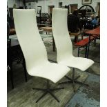 SWIVEL CHAIRS, a pair, Danish by Fritz Hansen with high backs in white upholstery, 46cm W x 124cm H.