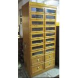 HABERDASHERY CABINET, mid 20th century oak with sixteen glazed and four further drawers below,