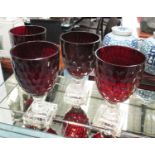 VASES, a set of four, with red bowls on clear glass bases, 29cm H.