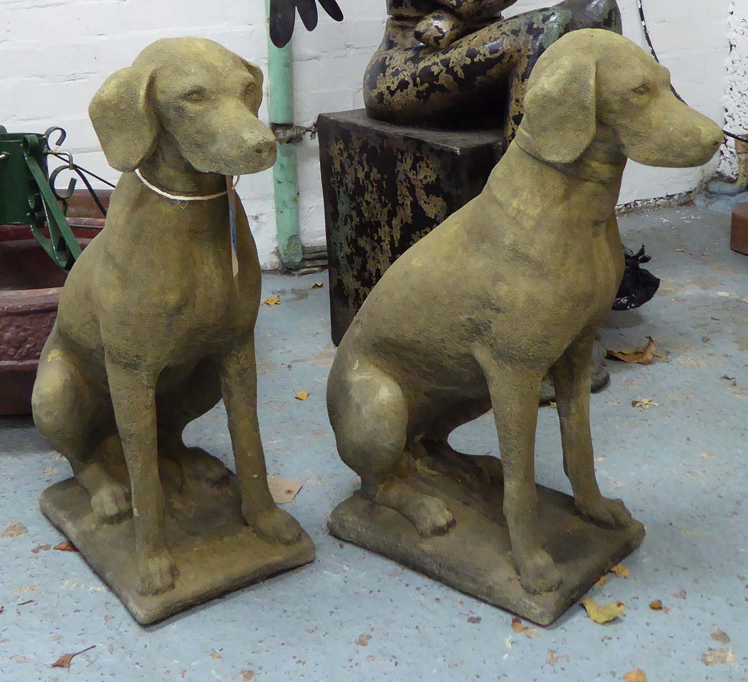 GARDEN DOG STATUES, a pair, 19th century 'Cotswold stone' style, in weathered finish, 75cm H x 58cm.