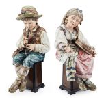 PAIR OF LARGE CONTINENTAL MAJOLICA FIGURES LATE 19TH/ EARLY 20TH CENTURY modelled as a boy with a