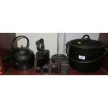 Blacked cast iron kitchenalia including kettle, iron, trivet, four weights and a lidded pot